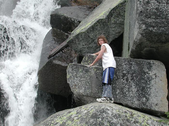 Andrew climbing next to waterfall