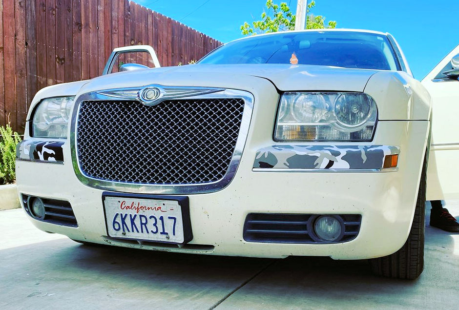 Chrysler 300 with small sections of camoflage wrapped under headlights